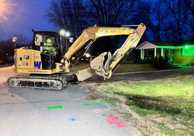 Excavator working on a street at night time.
