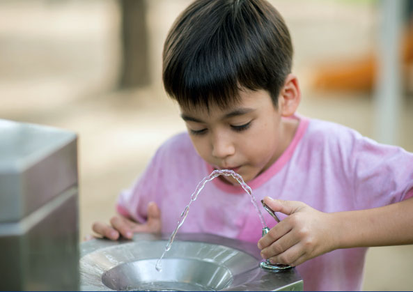 Boy drinking from fountain