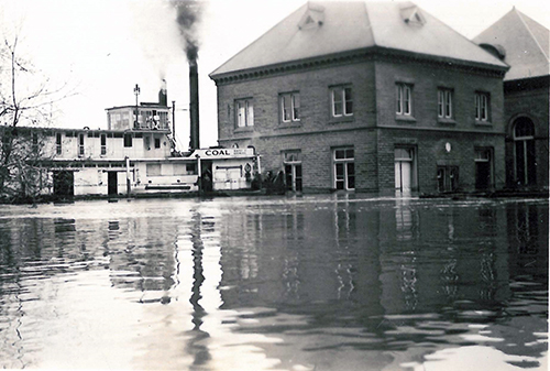 The 1937 flood with steamboat next to pumping station