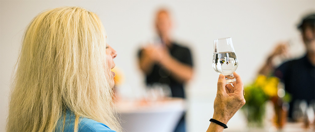 Kelley at a water tasting holding up glass